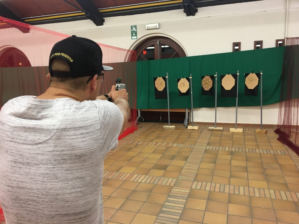man die met airsoft pistool schiet indoor op 5 ipsc targets